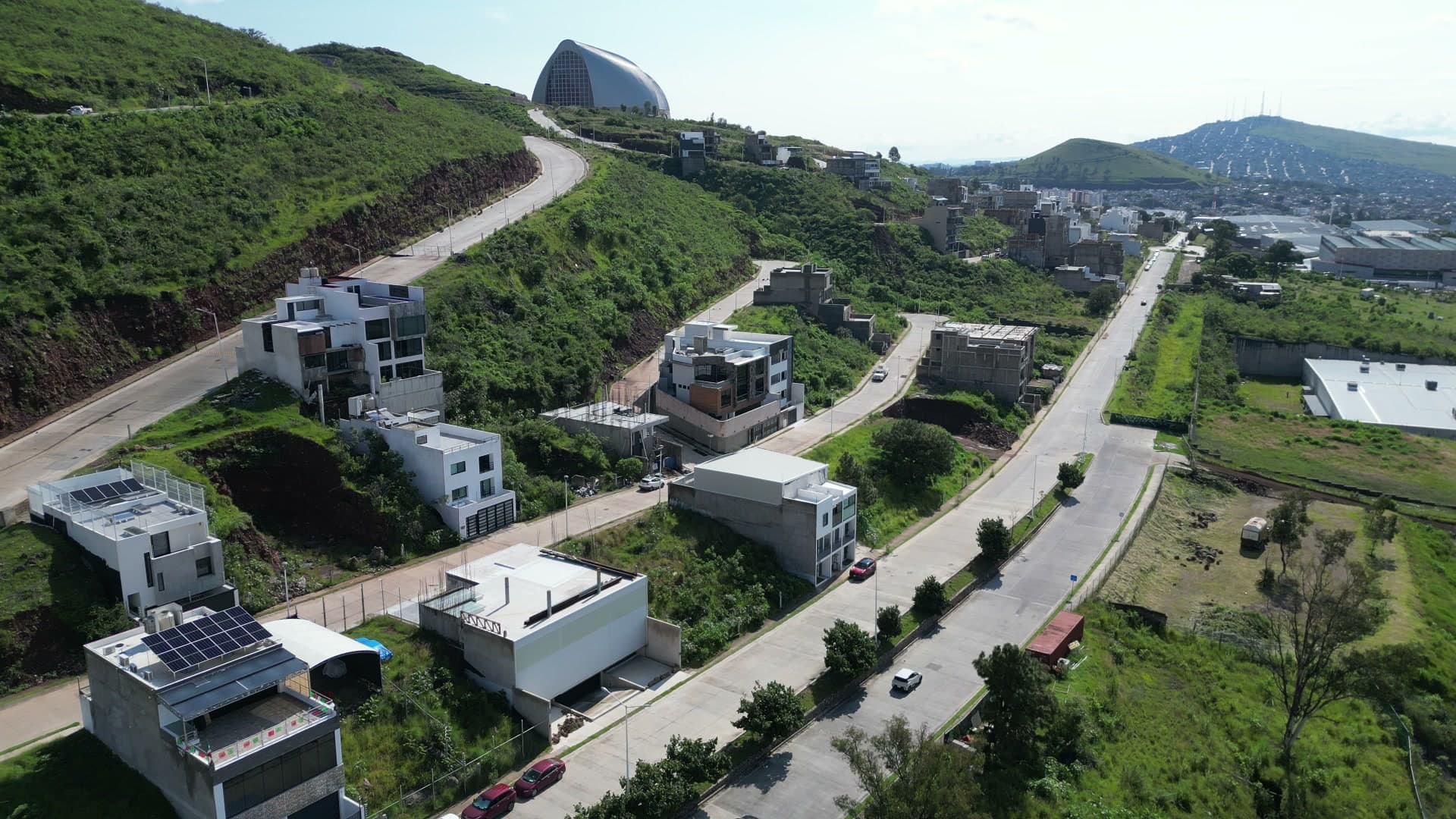 Vista aérea — zona residencial del Cerro del Tesoro con cerros verdes