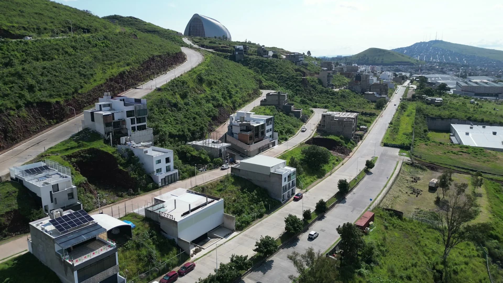 Vista aérea — zona residencial del Cerro del Tesoro con cerros verdes